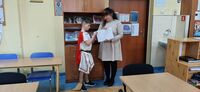 uczeń otwiera kopertę z pytaniami, kopertę trzyma nauczycielka