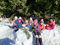 Dziewczyny budują fortecę ze śniegu.